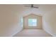 Carpeted primary bedroom with vaulted ceiling, a ceiling fan, and large windows allowing for plenty of natural light at 9531 Vira Dr, Raleigh, NC 27617