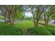 Neighborhood view of a manicured lawn, surrounded by trees, bushes, and sidewalk; brick homes visible at 9531 Vira Dr, Raleigh, NC 27617