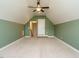 View of carpeted attic area featuring a ceiling fan and access door at 96 Ada Cir, Selma, NC 27576