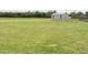 Large fenced backyard featuring a well-maintained lawn and a storage shed at 96 Ada Cir, Selma, NC 27576