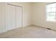 Neutral bedroom featuring carpeted floors, a window with natural light and closet with white doors at 96 Ada Cir, Selma, NC 27576