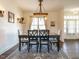 Open dining room with wood floors, shiplap accent wall, a rustic chandelier and large area rug at 96 Ada Cir, Selma, NC 27576