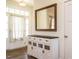 Bright entryway with a white cabinet, wood floors, large mirror, and a door with side-light windows at 96 Ada Cir, Selma, NC 27576