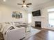 Comfortable living room with fireplace, ceiling fan, hardwood floors, and a large sectional sofa at 96 Ada Cir, Selma, NC 27576