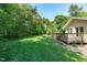 Expansive backyard with a wooden deck, offering a serene outdoor living space surrounded by trees at 1005 Greenwood Cir, Cary, NC 27511