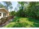 Spacious backyard with a deck, lush lawn, and mature trees offering shade and privacy at 1005 Greenwood Cir, Cary, NC 27511