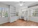 A cozy bedroom featuring built-in shelving and a vanity, complemented by hardwood floors at 1005 Greenwood Cir, Cary, NC 27511