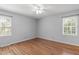Inviting bedroom with hardwood floors and natural light from two windows at 1005 Greenwood Cir, Cary, NC 27511