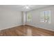 Cozy bedroom with hardwood floors, natural light from two windows, and a closet at 1005 Greenwood Cir, Cary, NC 27511