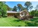 Charming home exterior featuring a well-maintained lawn, wooden deck, and inviting backyard at 1005 Greenwood Cir, Cary, NC 27511