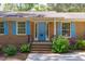 Welcoming front entrance with a bright blue door, brick steps, and manicured landscaping at 1005 Greenwood Cir, Cary, NC 27511