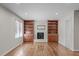 Cozy living room featuring hardwood floors, a painted brick fireplace, and custom built-in bookshelves at 1005 Greenwood Cir, Cary, NC 27511