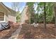 Landscaped backyard featuring mulch, mature trees, decorative rock garden and two Adirondack chairs at 102 Parkbranch Ln, Cary, NC 27519