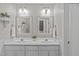 Bathroom featuring double sink vanity with decorative mirrors and sconce lighting at 102 Parkbranch Ln, Cary, NC 27519