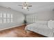 Bright bedroom features hardwood floors, modern ceiling fan, and plantation shutters at 102 Parkbranch Ln, Cary, NC 27519