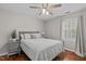 Comfortable bedroom featuring hardwood floors, ceiling fan, and a window with natural light and neutral decor at 102 Parkbranch Ln, Cary, NC 27519