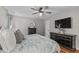 Comfortable bedroom with a ceiling fan, decorative mirror, and dresser at 102 Parkbranch Ln, Cary, NC 27519