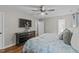 Well-lit bedroom with a ceiling fan, TV, dresser and decorative items at 102 Parkbranch Ln, Cary, NC 27519