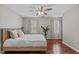 Cozy bedroom with hardwood floors, ceiling fan, and large windows with natural light and neutral decor at 102 Parkbranch Ln, Cary, NC 27519