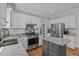 Bright kitchen features stainless appliances, granite countertops, white cabinets, and a gray kitchen island at 102 Parkbranch Ln, Cary, NC 27519