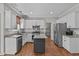 Well-lit kitchen featuring white cabinets, granite countertops, and stainless steel appliances at 102 Parkbranch Ln, Cary, NC 27519