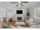 Bright living room featuring a fireplace, hardwood floors, and a comfortable sectional sofa at 102 Parkbranch Ln, Cary, NC 27519