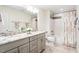 Bathroom featuring double sink vanity with granite countertops, tiled floors, and a shower with patterned curtain at 103 Caymus Ct, Cary, NC 27519