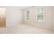 Bright bedroom featuring neutral carpet, two windows with natural light, and an open closet for storage at 103 Caymus Ct, Cary, NC 27519