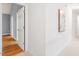 Hallway leading to a room with hardwood floors and light blue walls, offering a view of the interior space at 103 Caymus Ct, Cary, NC 27519