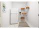 Functional laundry room featuring a white refrigerator, shelving units, and neutral decor for organized living at 103 Caymus Ct, Cary, NC 27519