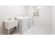 Functional laundry room with a utility sink, washer, dryer, and a window for natural light at 103 Caymus Ct, Cary, NC 27519