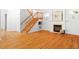 Open living space featuring hardwood floors, a fireplace, and staircase, creating a warm and inviting atmosphere at 103 Caymus Ct, Cary, NC 27519
