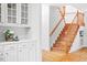 Elegant staircase featuring hardwood steps, white walls, and built-in cabinetry with decorative details at 103 Caymus Ct, Cary, NC 27519