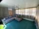 Relaxing sunroom with ample natural light, a comfortable couch, and green flooring at 104 N 16Th St, Erwin, NC 28339