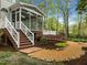 A brick walkway with steps leads to a patio and screened-in porch of a home in a wooded area at 105 Toynbee Pl, Chapel Hill, NC 27514
