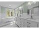 Bright bathroom with double vanity, soaking tub, and large windows overlooking the yard at 105 Toynbee Pl, Chapel Hill, NC 27514