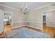 Neutral dining room features wood floors, modern chandelier, and open access to adjacent rooms, perfect for gatherings at 105 Toynbee Pl, Chapel Hill, NC 27514