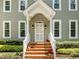 Front porch of a two-story house with brick steps, white railings, and potted flowers adding charm and curb appeal at 105 Toynbee Pl, Chapel Hill, NC 27514