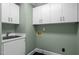 A practical laundry room features storage cabinets above the utility sink at 105 Toynbee Pl, Chapel Hill, NC 27514