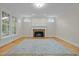 Bright living room features hardwood floors, brick fireplace, and many windows at 105 Toynbee Pl, Chapel Hill, NC 27514