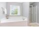 Bright bathroom with a tub and a separate glass door shower is perfect for relaxation and convenience at 1109 Forest Willow Ln, Morrisville, NC 27560