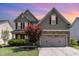 Two story home with green siding, stone accents, a two-car garage and beautifully landscaped front yard at 1109 Forest Willow Ln, Morrisville, NC 27560