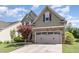 Two story home with green siding, stone accents, a two-car garage and beautifully landscaped front yard at 1109 Forest Willow Ln, Morrisville, NC 27560