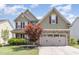 Two story home with green siding, stone accents, a two-car garage and beautifully landscaped front yard at 1109 Forest Willow Ln, Morrisville, NC 27560