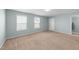 Bright bedroom with large windows, neutral carpet, and a mirrored closet at 1126 Russet Ln, Apex, NC 27523