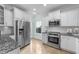 Kitchen featuring stainless steel appliances, white cabinetry, and granite countertops at 1126 Russet Ln, Apex, NC 27523