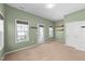 Bright office space with three windows, wood shelving, and a glass-paned door to the outside at 1126 Russet Ln, Apex, NC 27523