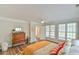 Sunny bedroom with hardwood floors, neutral walls, ceiling fan, and natural light from large windows at 116 Crawford Rd, Hillsborough, NC 27278