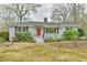 Exterior shot of the home with a red door, showing the front yard, landscape and brick exterior at 116 Crawford Rd, Hillsborough, NC 27278