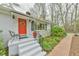 Charming exterior of a single-story home with a bright red door, brick walkway and fresh landscaping at 116 Crawford Rd, Hillsborough, NC 27278